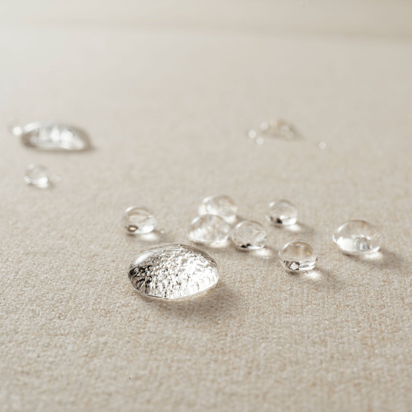 A close-up of water droplets on Rezy Sofa's sophisticated stain-resistant fabric